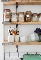 Storage jars on wooden kitchen shelves 