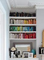 Built in shelves with books displayed in colour blocks 