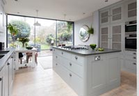 Pale grey contemporary kitchen with glazed doors to the garden 
