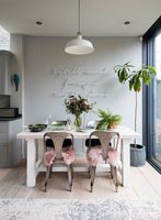 Contemporary dining room with neon light art and fluffy cushions 
