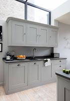Grey kitchen units and sink in contemporary kitchen 
