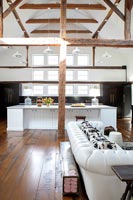 White furniture and island in wooden country open plan living space 