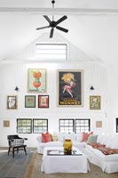 Display of colourful artwork and ceiling fan in modern country living room 