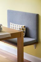 Built in bench seat in dining room with yellow painted walls 
