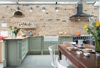 Modern kitchen diner with exposed brick wall 