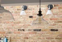 Pendant and wall lights on exposed brick wall 