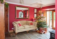 Red painted country living room decorated for Christmas 