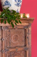 Detail of candles on antique furniture with evergreen foliage 