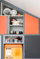 Built-in cabinets and shelve with different coloured doors 