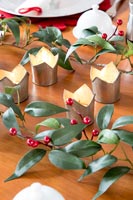 Christmas decorations and candles on dining table 