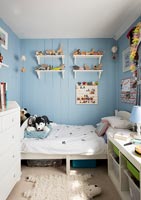 Blue painted wooden paneled walls in childrens bedroom 