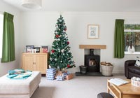Christmas tree next to fireplace in modern living room 