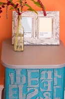 Distressed picture frames with pantone colour samples on modern side table 