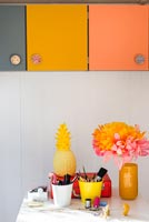 Colourful cupboards and accessories on desk in home office 