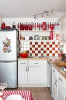 Red and white kitchen with display of figures on shelf 