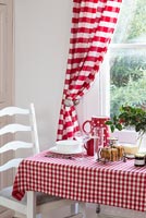 Checkered tablecloth and striped curtains in kitchen diner 