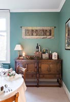 Wooden sideboard in dining room with teal painted walls - at Christmas 