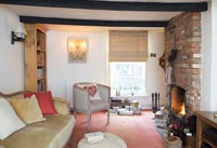 Cosy cottage living room with lit fire 