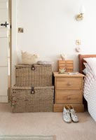 Bedside table and baskets next to bed 