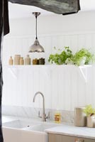 Double butler sink and herbs on shelf in modern country kitchen 