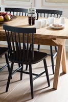 Black painted chairs next to wooden table 