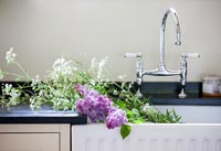 Detail of cut flowers in sink in country kitchen 