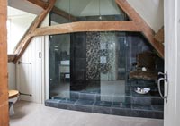 Bathroom with enclosed shower area and exposed wooden beams 