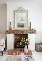 Brick fireplace with exposed wooden beam as mantelpiece 