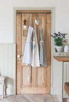 Aprons hanging on wooden door 
