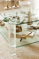 Display of collectibles in two tiered glass coffee table 