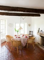 Wicker chairs around table in country dining room 