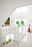 Bright red electric guitar in white contemporary hallway 