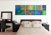 Modern bedroom with dressing table and colourful painting 