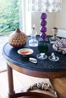 Collection of glassware and ornaments on marble topped table 