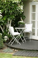 White metal cafe table and chairs on small decked area
