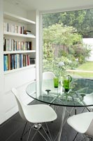 Glass circular dining table by window 