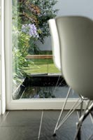 Modern water feature visible through dining room window 