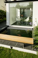 Fish in modern pond with large window to dining room 