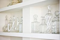 Collection of glassware on white shelves 