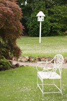 Dovecote and chair in country garden 