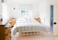 Modern country bedroom with large metal framed bed 