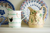 Decorative ceramic jugs on shelf 