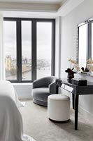 Modern bedroom furniture with city views through window 