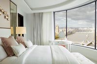 Modern bedroom with curved window and views of River Thames in London 