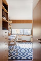 Blue and white patterned rug in wooden home office 
