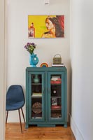 Blue painted cabinet and colourful artwork 