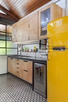 Modern industrial kitchen with bright yellow fridge freezer 