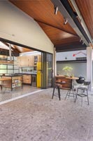 Barbecue area on terrace outside kitchen with open sliding doors 