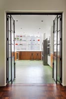 View through bi-fold internal doors to contemporary industrial kitchen