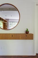 Wall mounted wooden unit and circular mirror